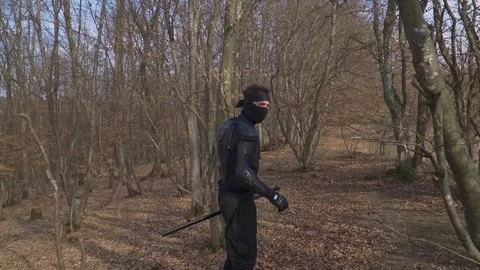 Stealthy Ninja Walking Through Dense Forest in Cinematic Action Scene Stock Footage 309852619