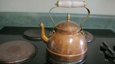 Steam Boils From a Copper Tea Kettle on a Stove Top Stock Footage 64111424