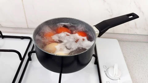 Steam Bubbles: Boiling Eggs in a Black Saucepan Stock Footage 317435213