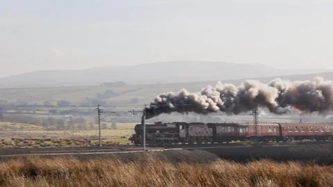 Steam engine 45699 'Galatea' and excursion train passing Tebay on Shap incline Stock Footage 86521294