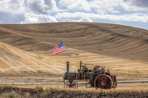 Steam engine and flag in field. Stock Photos
