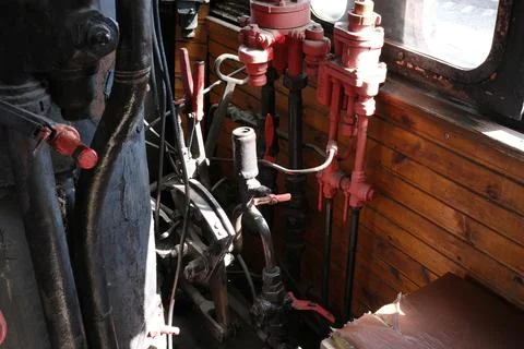Steam engine controls inside a vintage locomotive cabin Stock Photos