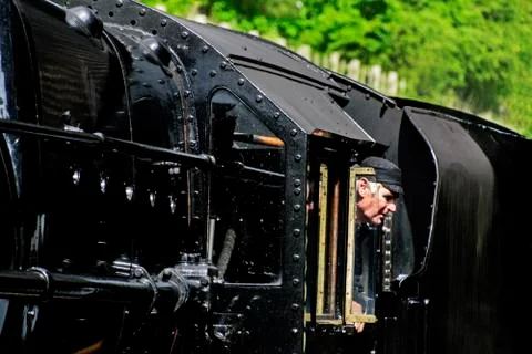 Steam engine driver looking from his Cab to the platform Stock Photos