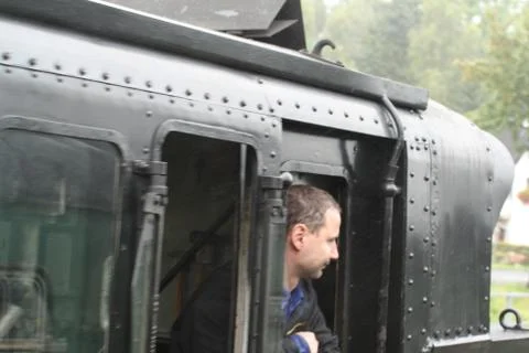 Steam engine driver at stop at station Stockfoto's