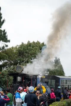 Steam engine train emitting smoke at Batasia Loop in Darjeeling India Stock Photos