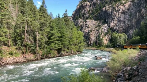 Steam engine turns a corner in a spectacular mountain river gorge Stock Footage 113877032