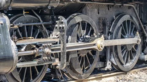 Steam Engine Wheels Show Movement at a Train Station in Daylight 스톡 사진