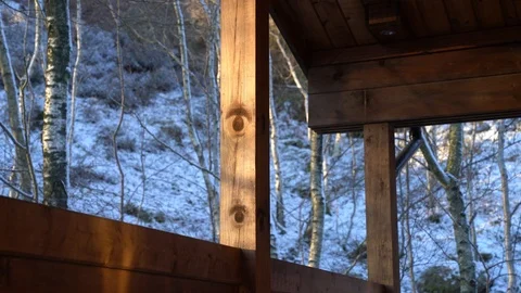 Steam illuminated by setting sun, drifting past log cabin veranda Stock Footage 86469200