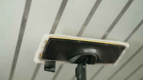 Steam mop effectively cleaning white ceiling with parallel decorative strips Video stock 318520974