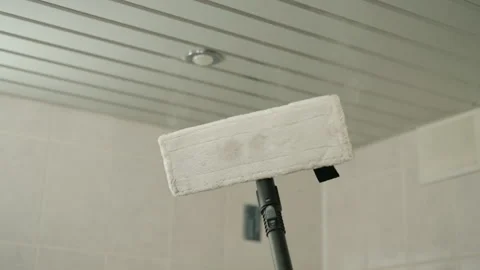 Steam mop with microfiber pad applying hot vapor to ceiling, effectively Stock Footage 318521350