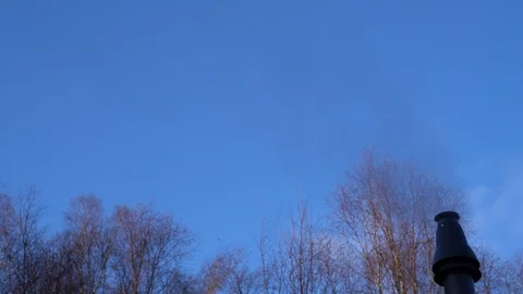 Steam released from flue on a cold winter's day with blue sky and treetops 스톡 동영상 86468958