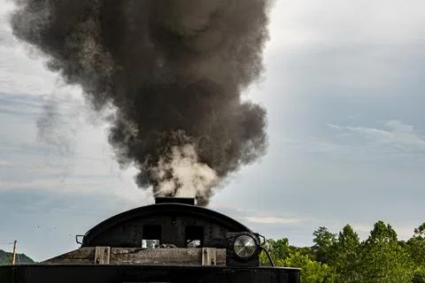 Steam Rises From the Chimney of a Train on a Cloudy Day in the Countryside .. Stock Photos