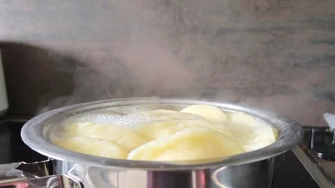 Steam rises from dumplings boiling in a pot of water. Video stock 342065432