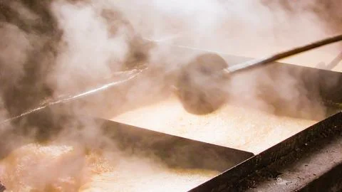 Steam rises from multiple vats where maple sap is boiled, producing authent.. Stock Photos