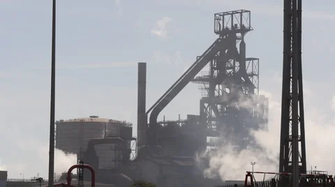 Steam rises from steelworks factory Stock Footage