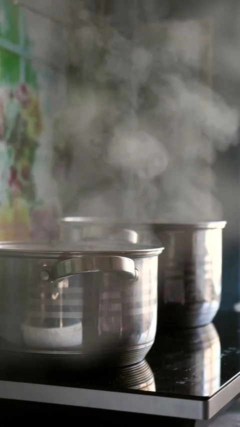 Steam rising from multiple pots boiling on a kitchen stove. Stock Footage 342024977