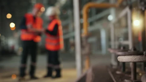 Steam taps, blurry background. Two workers industrial plant, working together Stock Footage 145771509