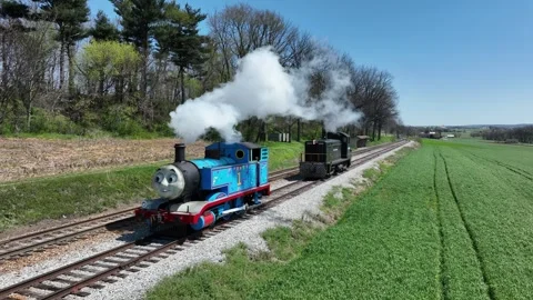 Steam Thomas Engine Rides Through Green Fields on a Sunny Day in Spring Nea.. Stock Footage 328986951