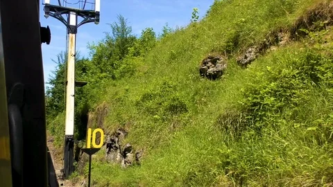 Steam train approaching countryside bridge and passenger station Stock Footage 80293147