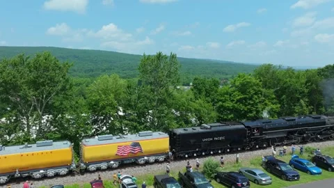 Steam Train Backs up Travels Through a Small Town With a View of Green Hill.. Stock Footage 340340401