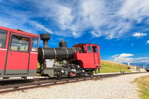 Steam train in a beautiful alpine landscape. Stock Photos