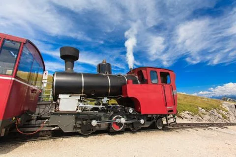 Steam train in a beautiful alpine landscape. Stock Photos