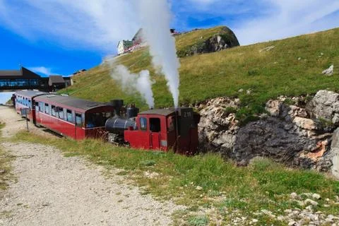 Steam train in a beautiful alpine landscape. Stock Photos
