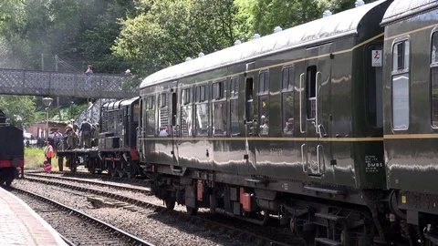 Steam Train comes into station carrying carriages and people 4K Stockbeeldmateriaal 77428016