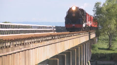Steam train crosses river bridge Stock Footage 883243