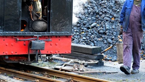 Steam train driver brings coal for engine Stock Footage 99614559
