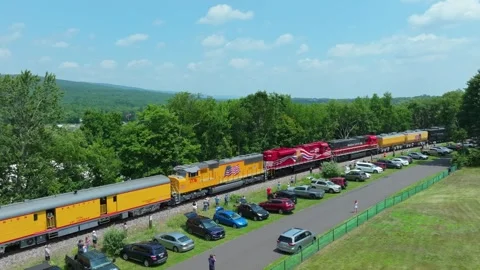 A steam train known as Big boy backing up through a park where people are Stock Footage 340405133