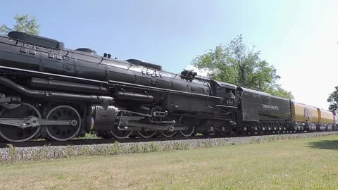 A steam train known as Big Boy moves slowly along railway tracks. It passes Stock Footage 340407314