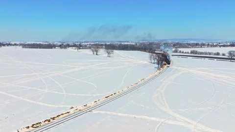 Steam Train Moves Through Snowy Landscape in Winter Stock Footage 341436219