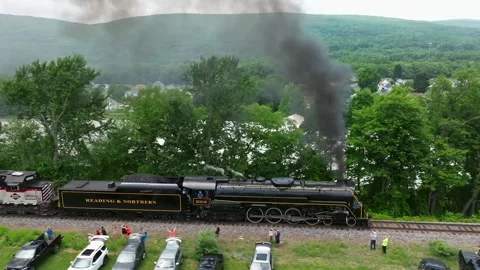 Steam Train Passes by on a Clear Day in the Countryside With People Watching Stock Footage 340340036