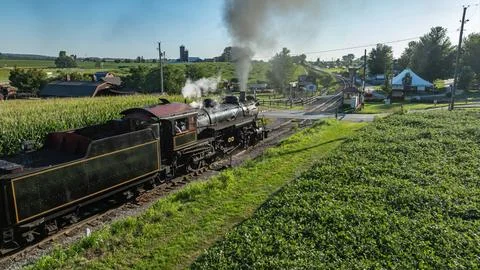 Steam Train Passes Through Rural Area Near Cornfields on a Sunny Day Фото