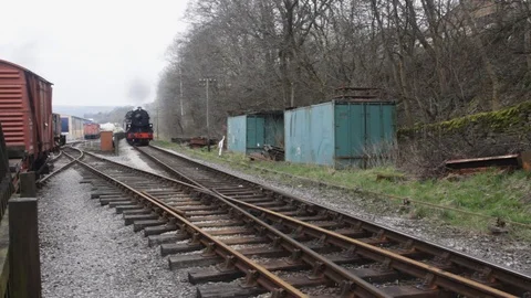 Steam train passing Ingrow station yard on Keighley &amp; Worth Valley Railway Stock Footage 105741377
