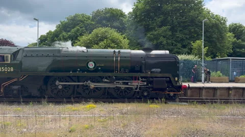 Steam train passing through a railway station Stock Footage 276572072