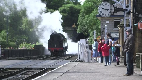 Steam train passing through yorkshire station Stock Footage 240581345