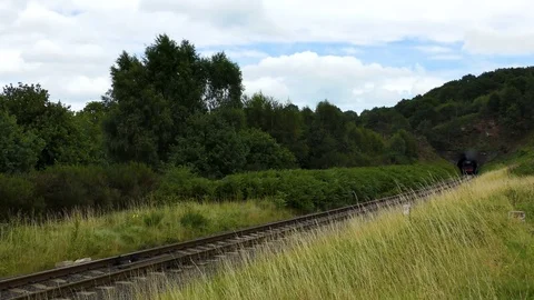 Steam train producing smoke emerging from railway tunnel Stock Footage 80293817