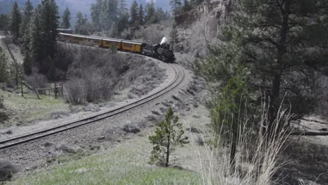 Steam train rounds a mountain bend on the Durango and Silverton railway Stock Footage 151988331