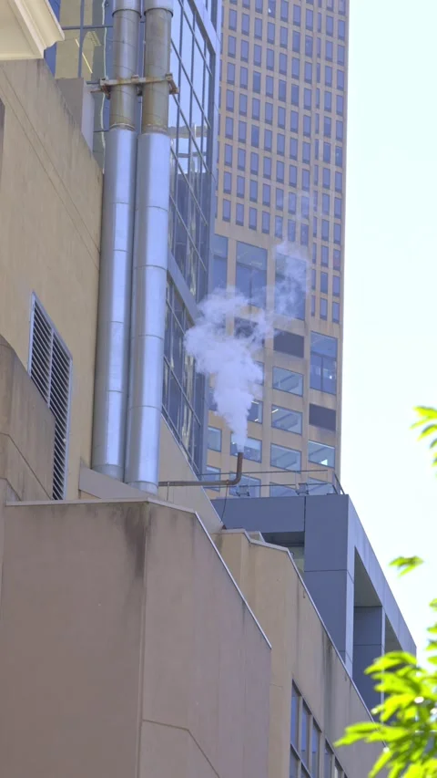 Steam Venting from Industrial Pipe Between City Buildings Vidéo 339647068