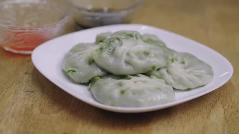 Steamed Chinese chive dumplings served on a white plate with dipping sauces.. Stock Footage 342781830