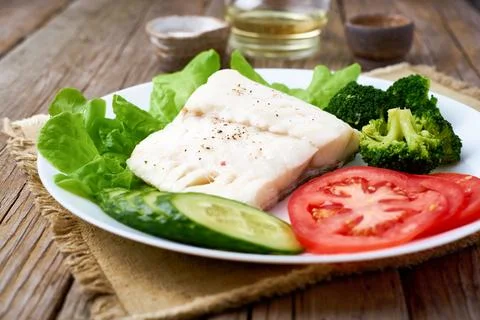 Steamed cod fish. Paleo, keto, fodmap healthy diet with vegetables Stock Photos