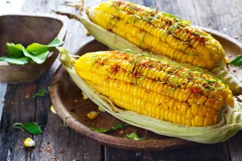 Steamed corn whith ingredient herb on wooden plate 스톡 사진