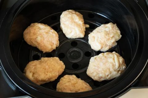 Steamed cutlets made from raw minced chicken lie in a multicooker, cooking st Stock Photos