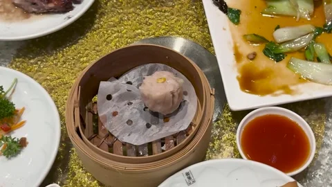 Steamed Dumpling in Bamboo Basket on Rotating Restaurant Table Stock Footage 328139116