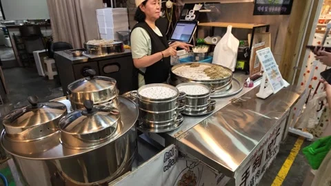 Steamed Dumpling Vendor Serving Customer at Indoor Market Stall in Jeju, South Vidéo 341180499
