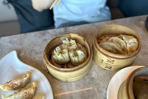 Steamed dumplings in bamboo baskets on a table. Stock Photos