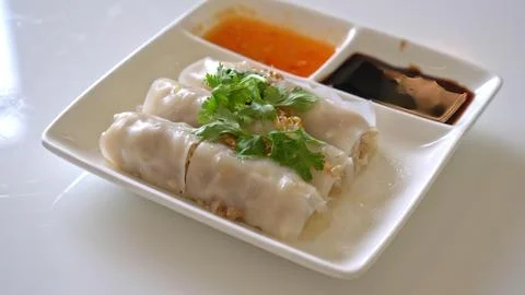Steamed spring rolls with herbs and dipping sauces on a white plate Stock Photos