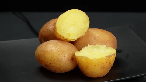 Steamed Yellow Potatoes Rotating on Black Plate Stock Footage 343944505